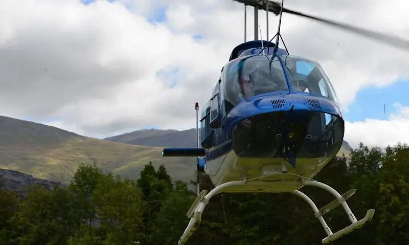 Bell JetRanger 207 flying over Snowdonia mountains